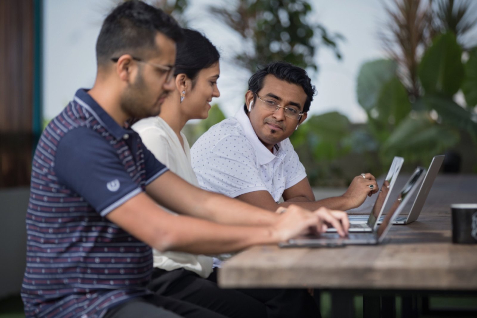 Tres personas trabajando juntas con sus computadoras