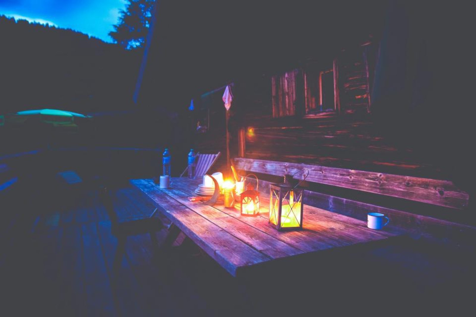 Deck de madera iluminado con faroles de noche