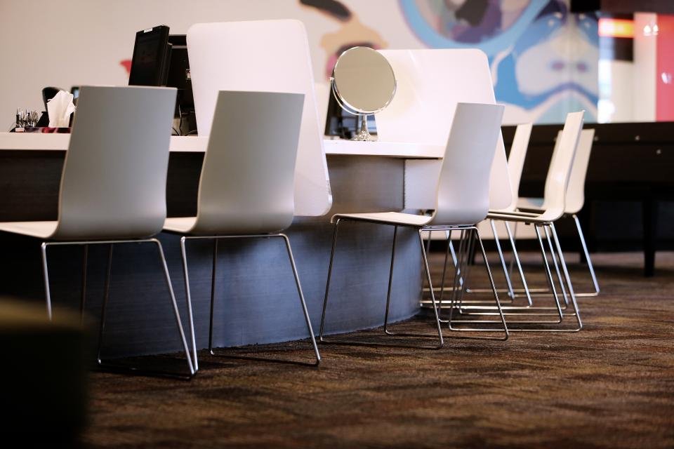 Interior de la peluquería con sillones y espejos